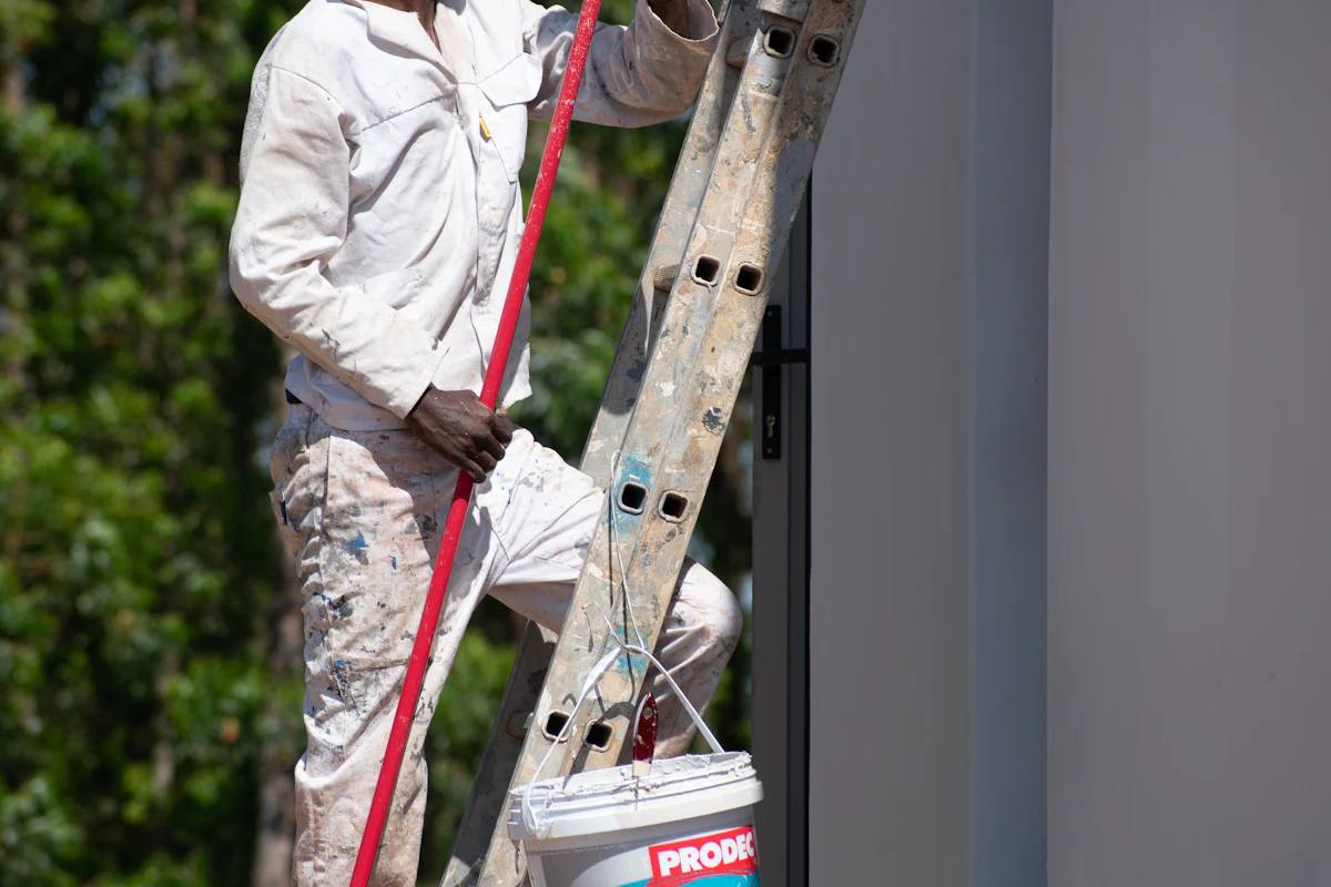 Painter on a ladder painting a wall