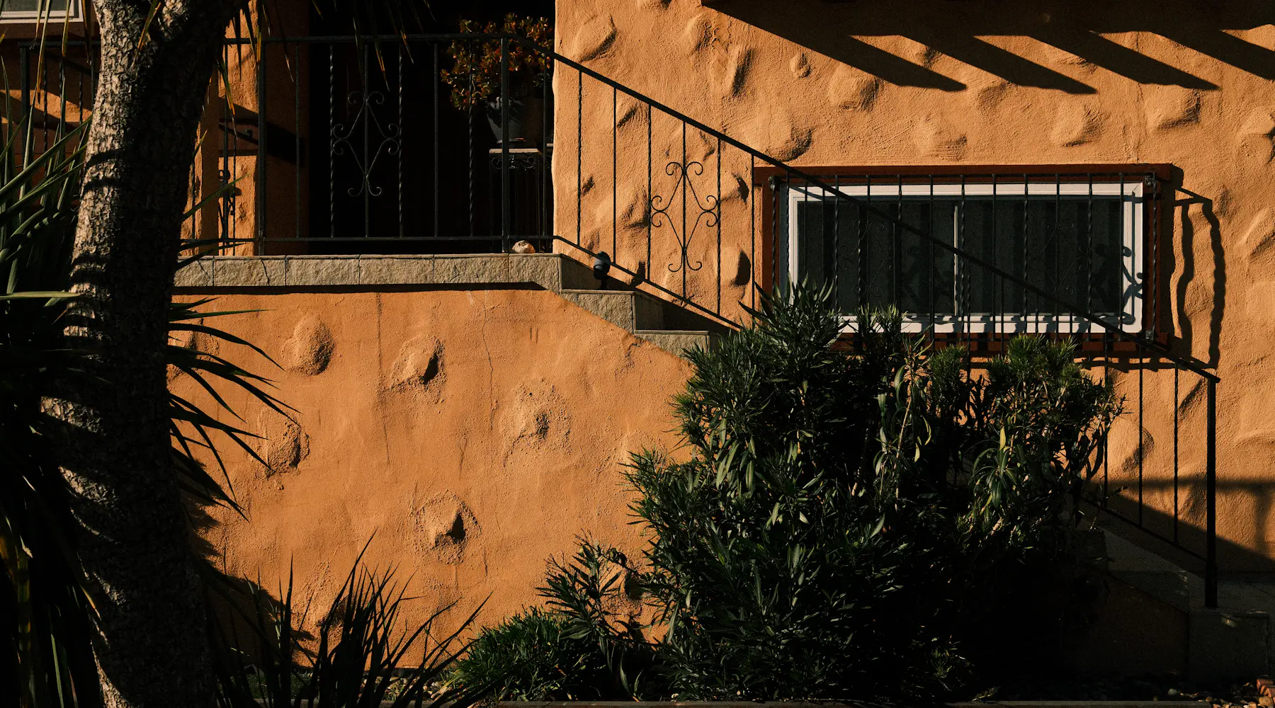 Stucco home exterior with steps and plants