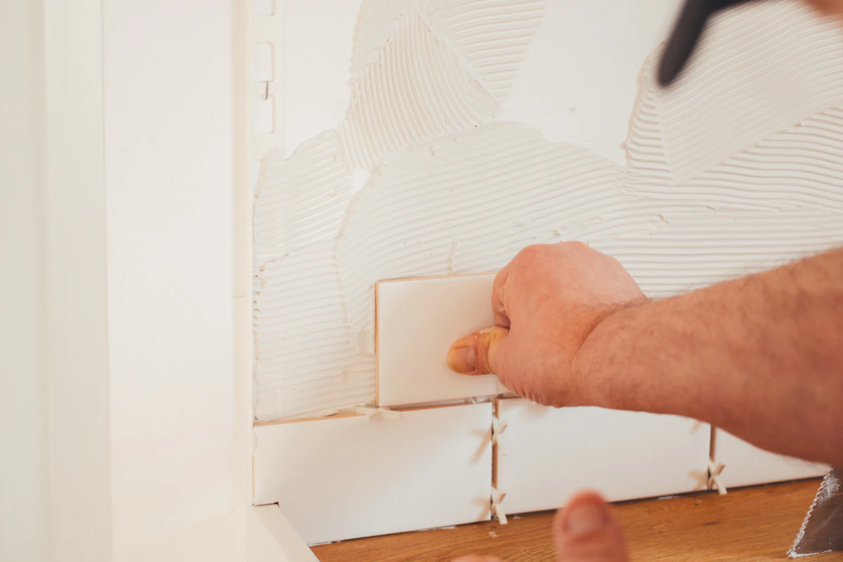 Setting tile on a white tiled wall